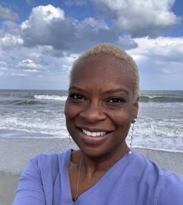 Rita Lynn Berry smiling by the ocean -- Therapist & Owner of NewVision