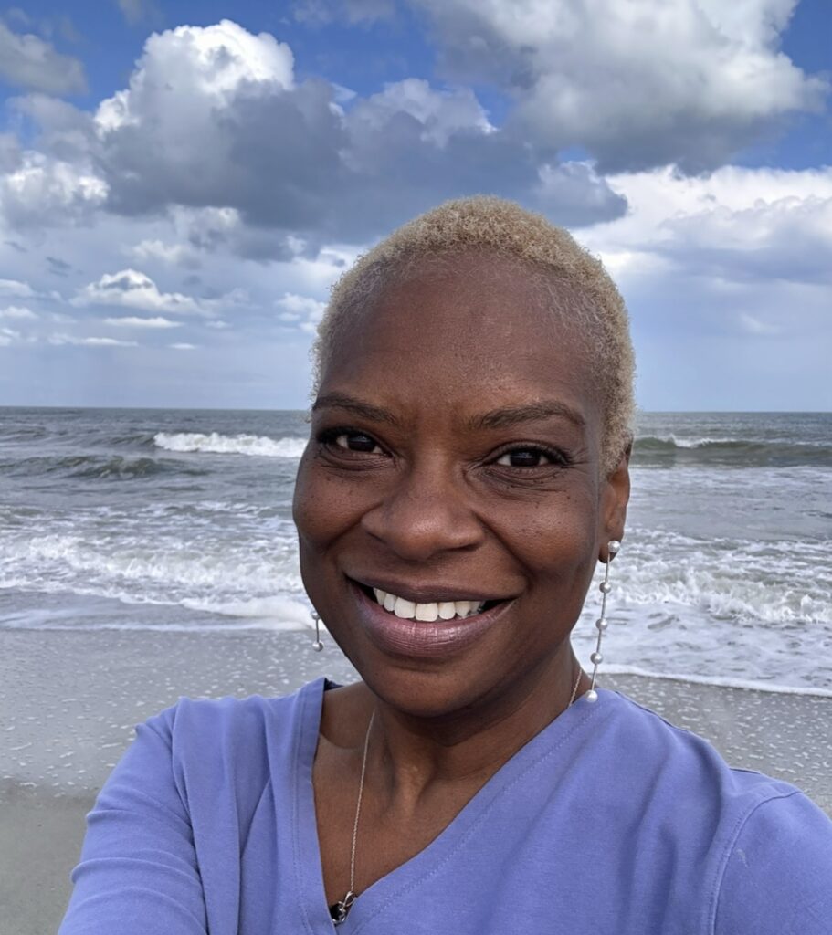 Rita Lynn Berry smiling by the ocean -- Therapist & Owner of NewVision
