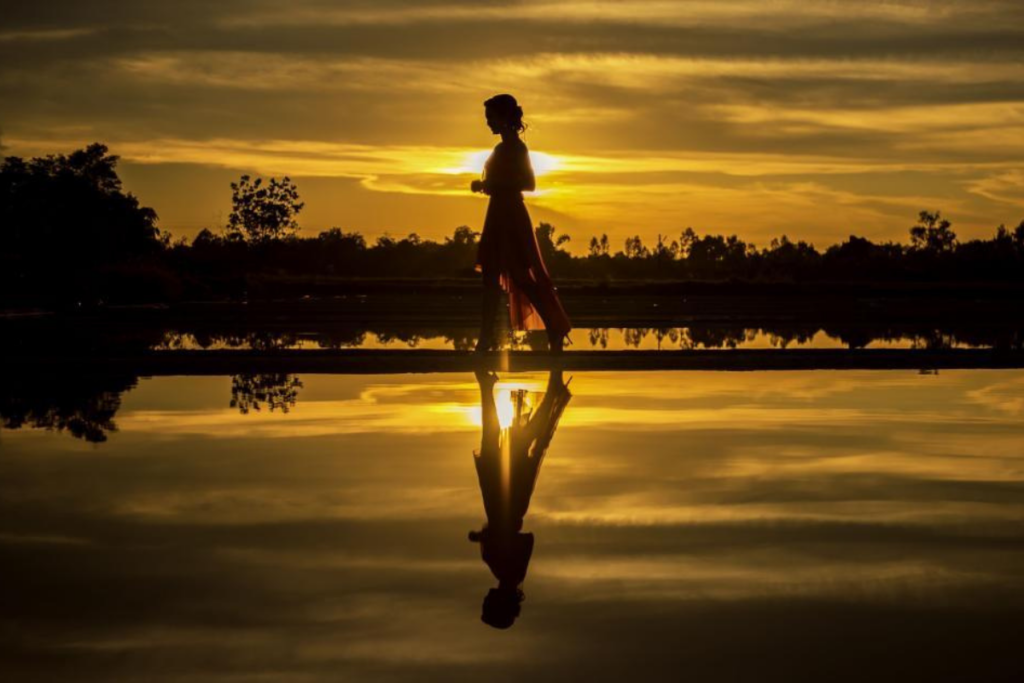 A woman standing quietly outdoors, reflecting during a period of starting over